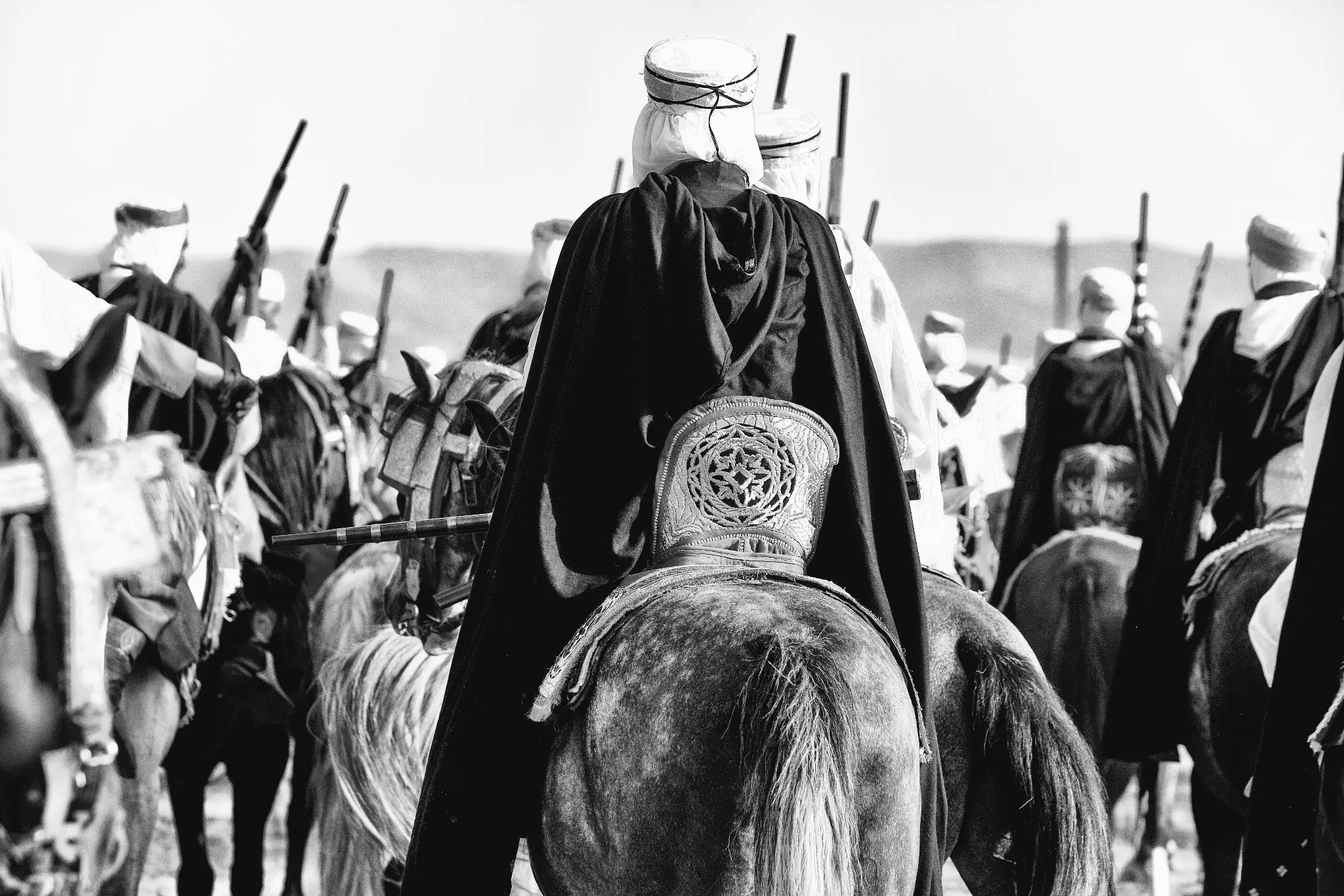 Cavaliers réunis à Sidi Boumediene, vus de dos avec leurs fusils traditionnels