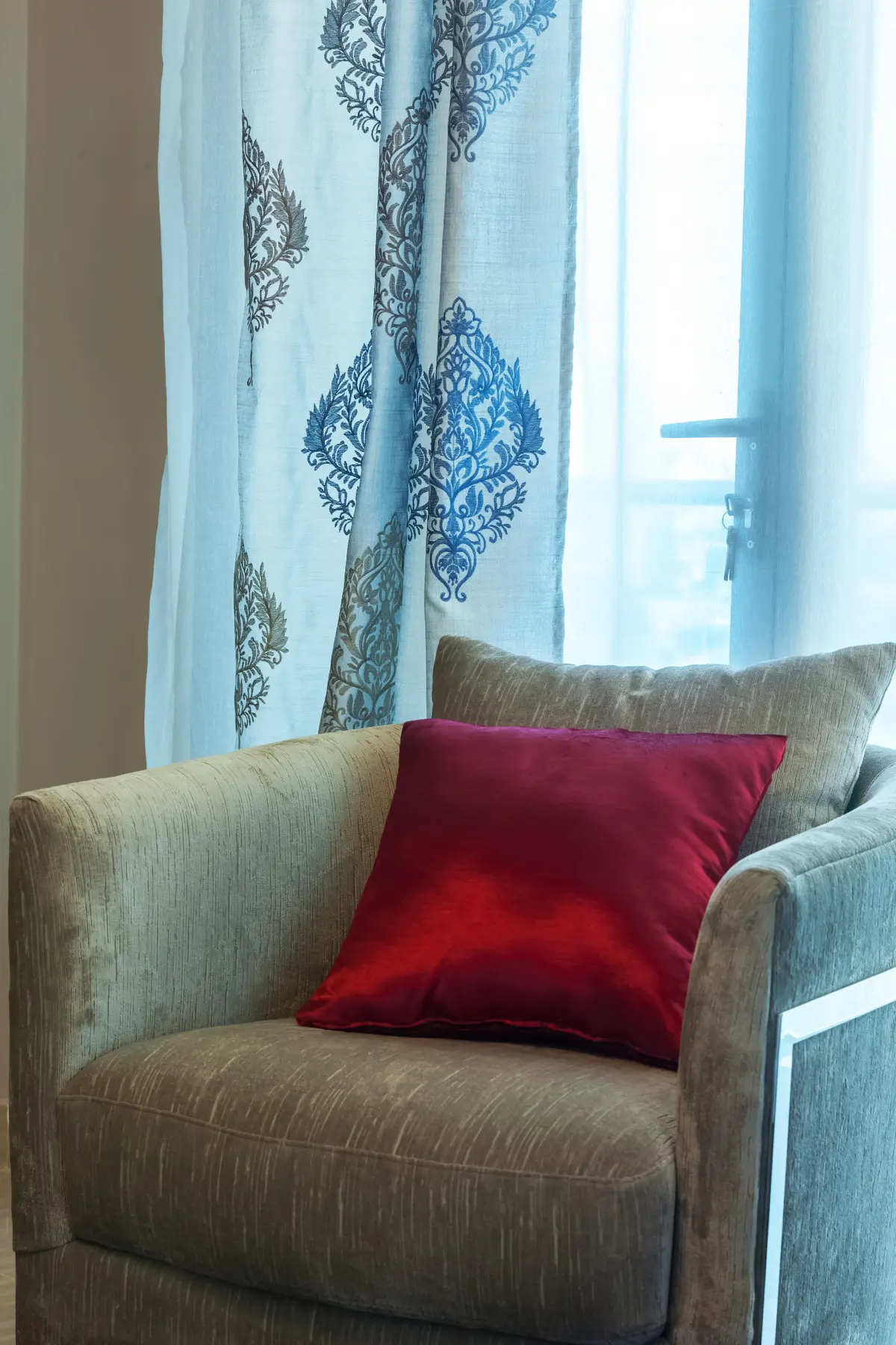 Fauteuil et coussin rouge près de la fenêtre